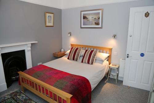 a bedroom with a large bed and a fireplace at Acorns Guest House in Combe Martin