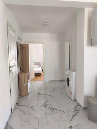 a white room with a washing machine in it at Apartmani Orlović Bar in Bar