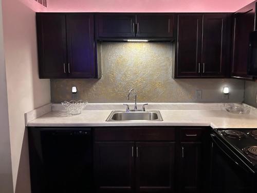 a kitchen with black cabinets and a sink at Union at the loop in Lawrence