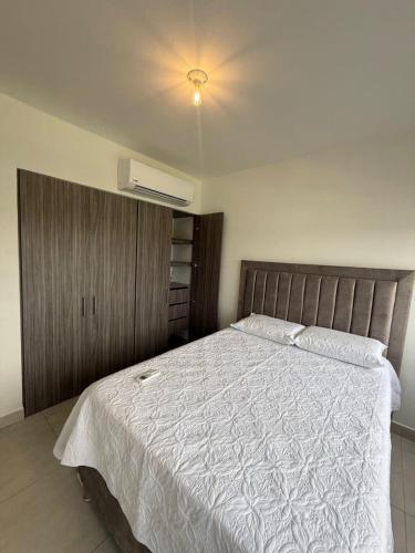 a bedroom with a large bed with a white comforter at Sensacional Apartamento Serena del Mar in Serena del Mar