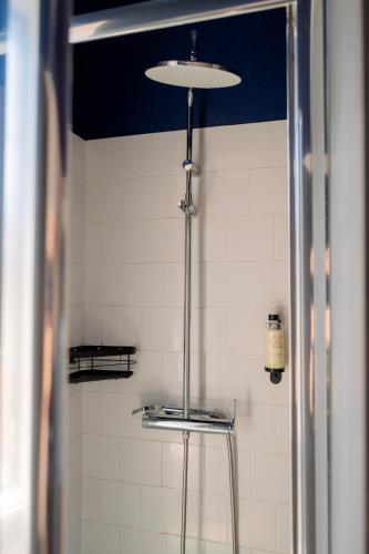 a bathroom with a white tiled wall and a light at Most Art Boutique Hostel in Leiria