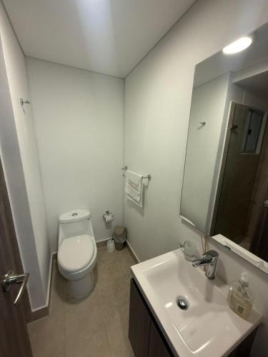 a bathroom with a toilet and a sink and a mirror at Sensacional Apartamento Serena del Mar in Serena del Mar