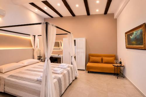 a bedroom with a bed and a couch in a room at RELAIS TORRE GLORIA in Naples