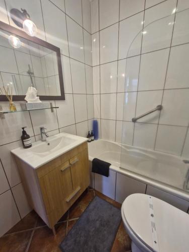 a bathroom with a sink and a tub and a toilet at Apartamento das Fontes in Furnas