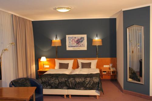 a hotel room with a bed and a desk at Grunau Hotel in Bayreuth