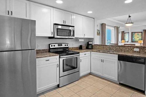 a kitchen with white cabinets and stainless steel appliances at 501-S - Sunset Vistas in St. Pete Beach