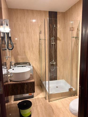 a bathroom with a shower and a sink and a tub at Leader Hotels Salmiya in Kuwait