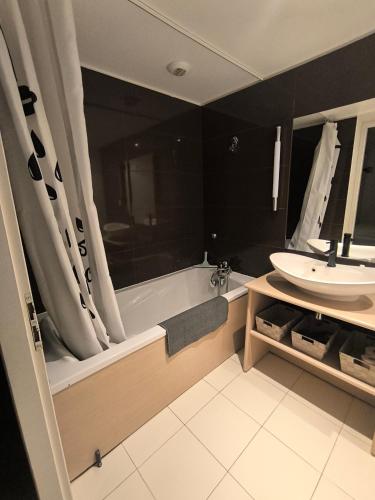 a bathroom with a bath tub and a sink at studio tout équipé in Jausiers