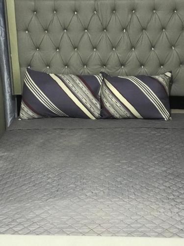 a bed with three pillows on top of it at Carib Ochi Rios condominium in Ocho Rios