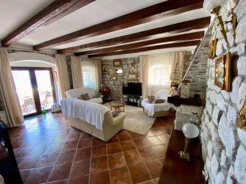 a living room with white furniture and a stone wall at House with a pier in Donji Morinj