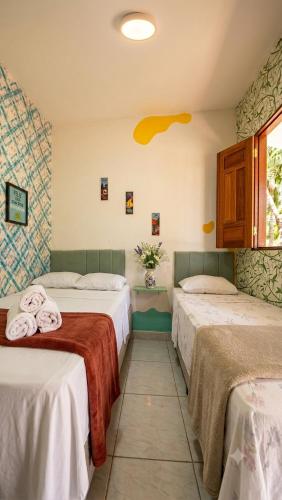 a hotel room with two beds with towels on them at Pousada da Sami in Barra de São Miguel
