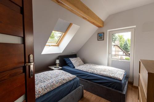 two beds in a small room with a window at LU-KA Apartamenty in Swornegacie