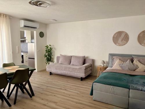 a bedroom with a bed and a couch and a table at Darius Apartment Kehl in Kehl am Rhein