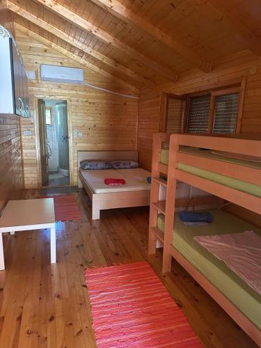 a room with bunk beds in a log cabin at Bojana Breeze in Ulcinj