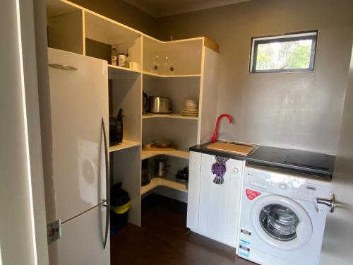 a kitchen with a washing machine and a refrigerator at Miranda Sea View Apartment in Miranda