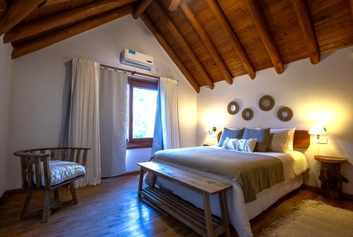 a bedroom with a bed and a chair and a window at Cabañas Murmullo de Agua in Mar de las Pampas