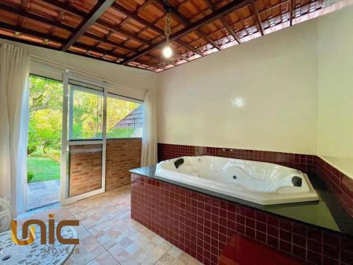 a large bathroom with a tub and a window at Loft em Teresópolis in Teresópolis