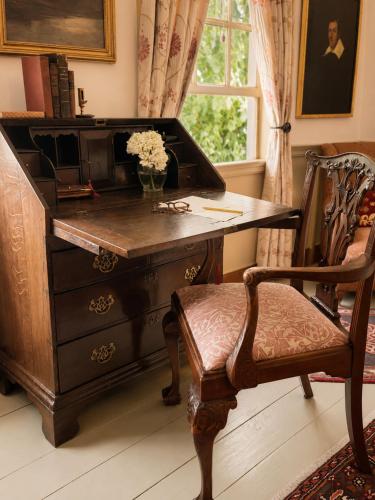 an office with a desk and a chair with a flower at Bailey House Inn - Georgian Waterfront Retreat in Annapolis Royal