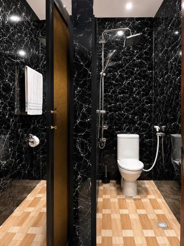a black bathroom with a toilet and a shower at Kaz An Nou in Cotonou