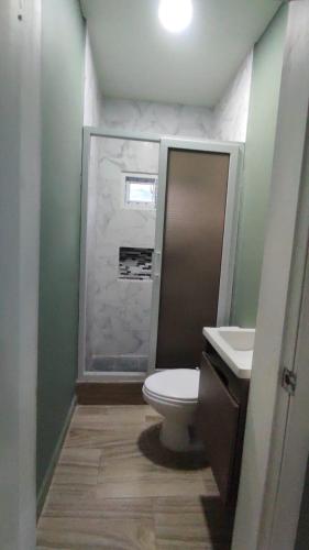 a bathroom with a toilet and a sink and a shower at Casa villeda in La Ceiba
