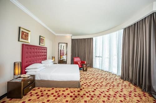 a hotel room with a bed and a large window at Kingsgate Hotel Doha by Millennium Hotels in Doha