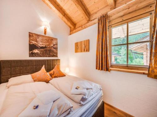 a bedroom with a bed with white sheets and a window at am Teich in Neukirchen am Großvenediger