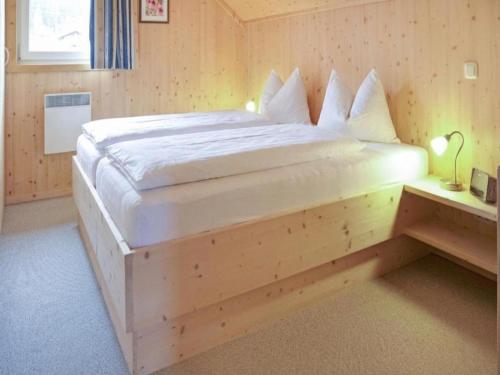 a large wooden bed in a room with a table at Sjenharieja in Stadl an der Mur
