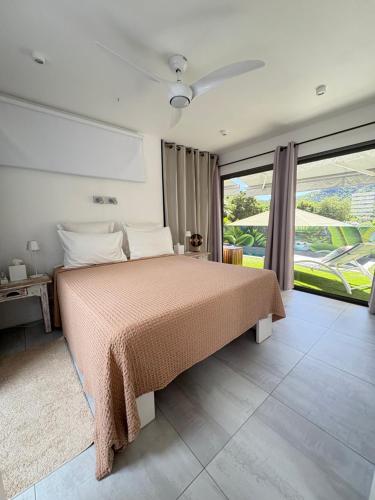 a bedroom with a bed and a large window at Fully-equipped house with pool in Grande Saline