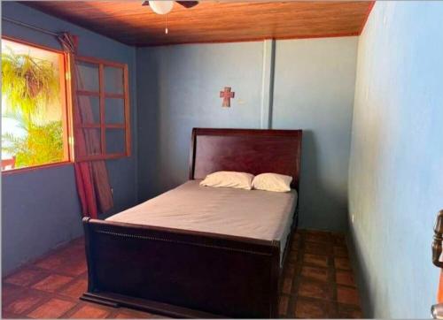 a bedroom with a bed with a cross on the wall at Ujarrás Getaway with Private Pool in Ujarrás