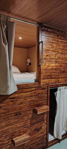 a small room with a bed and a mirror at VNJ Capsule 159 in Hoi An