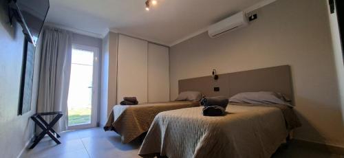 a hotel room with two beds and a window at Casa Prado in San Fernando del Valle de Catamarca