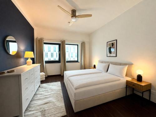 a bedroom with a large white bed and a dresser at Bheaven I Captains Apartment in Bremerhaven