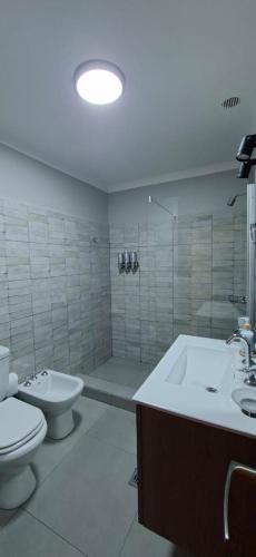 a bathroom with a toilet and a sink and a tub at Casa Prado in San Fernando del Valle de Catamarca