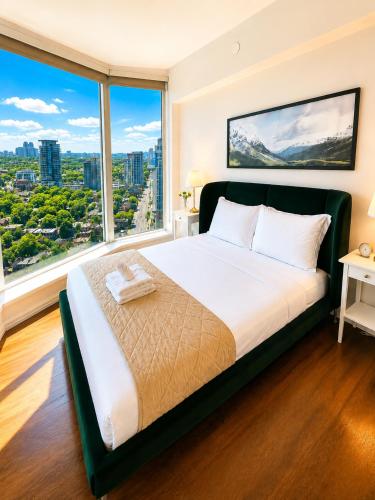 a bedroom with a large bed with a large window at Luxury 3-Beds Apartment in Yorkville with the Best City View in Downtown Toronto in Toronto
