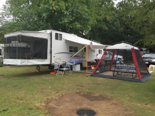 a white trailer with a tent in a field at Dragon City in Maryville