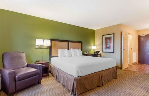 a hotel room with a bed and a chair at Extended Stay America Suites - Dublin - Hacienda Dr in Dublin