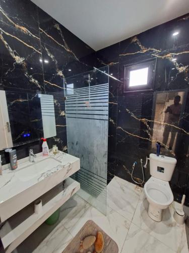 a bathroom with a shower and a toilet and a sink at Omaima villa in Taguermess