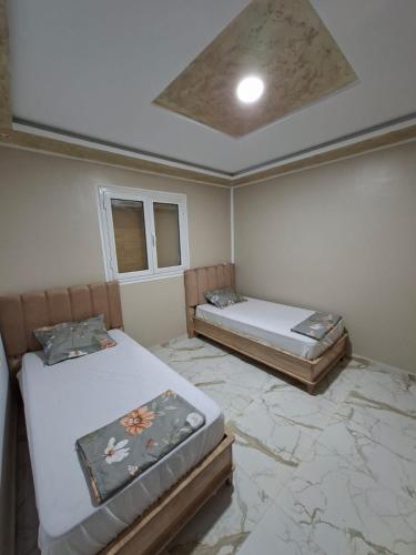 a room with two beds and a ceiling at Omaima villa in Taguermess