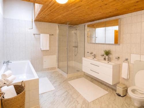 a bathroom with a tub and a toilet and a sink at Alpine Serviced Apartment with Mountain Views in Cazis
