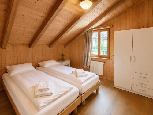 a bedroom with two beds in a wooden room at Alpine Serviced Apartment with Mountain Views in Cazis