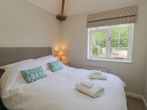 a bedroom with a white bed with towels on it at The Cider Press, Motcombe, Shaftesbury in Motcombe