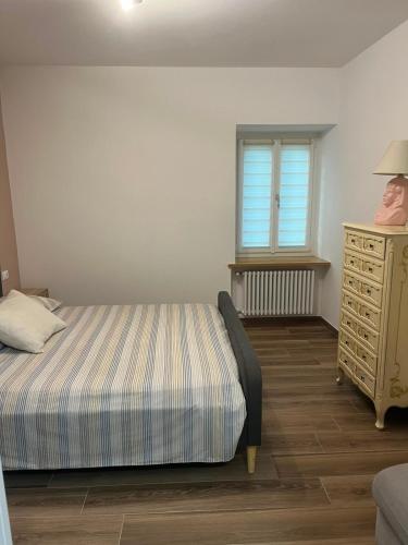a bedroom with a bed and a dresser and a window at Al Vicolo in Telve