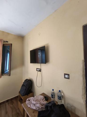 a room with a bed and a tv on the wall at Hotel New Aroma inn in Tājganj