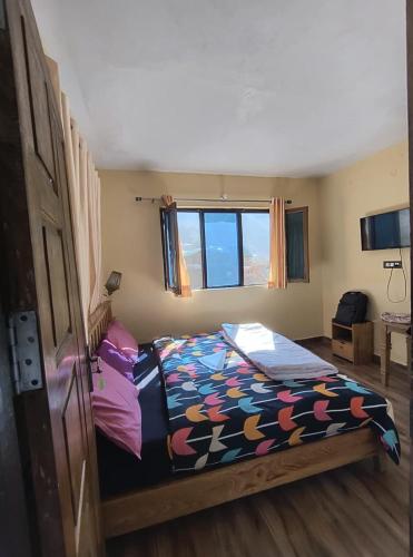 a bedroom with a bed with a colorful comforter at Hotel New Aroma inn in Tājganj