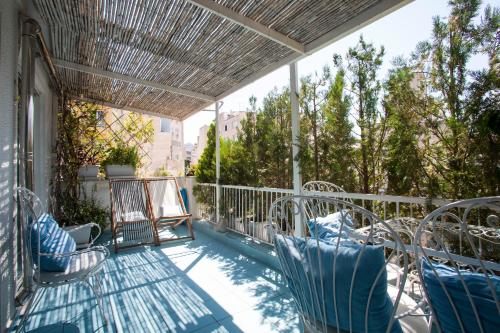 een balkon met stoelen en een parasol op een gebouw bij Modern, fully equipped apt with private balcony - CT1 in Athene