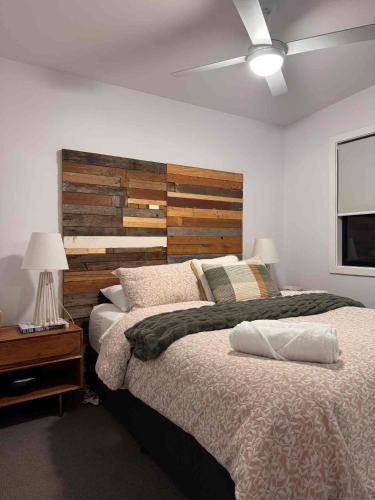 a bedroom with a large bed with a wooden headboard at Guest favourite Ocean Views Breakfast Included in Charlestown