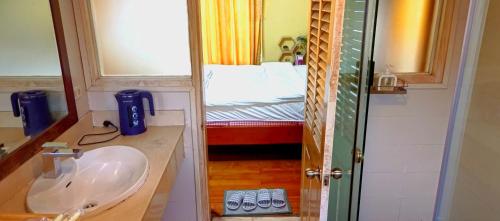 a bathroom with a sink and a bedroom with a bed at GuInn in Hanoi