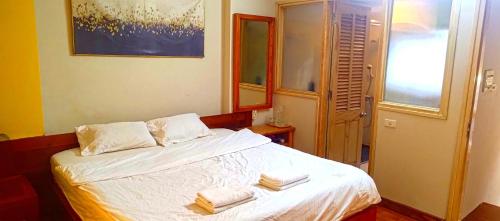 a bedroom with a bed with two towels on it at GuInn in Hanoi