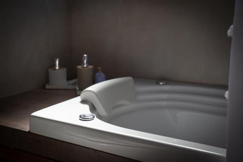 a white bath tub in a bathroom with two sinks at Cabañas Murmullo de Agua in Mar de las Pampas