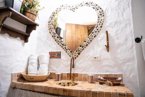 a bathroom with a heart mirror on the wall at Hotel Boutique Macaregua Girón in Girón